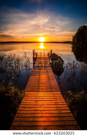 Sunset over the fishing pier at the lake in rural Finland Royalty-Free Stock Photo #623263025