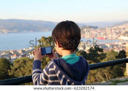 little kid taking photos in a viewpoint