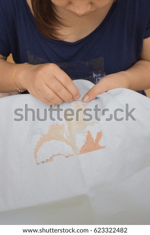 woman doing cross stitch