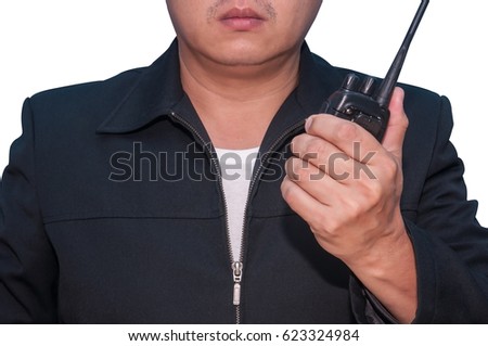 Unidentified security guard or business man holding and using small walkie-talkie.