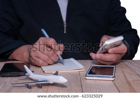 Unidentified business man using smartphone for planning and working with airplane model.