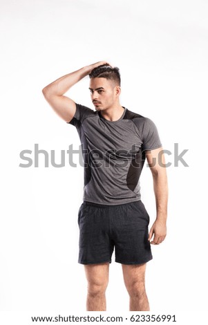 Young handsome fitness man in gray t-shirt, studio shot.