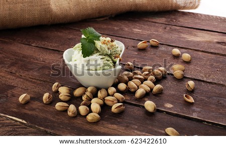 Pistachio ice cream with chopped nuts and honey on a rustic background
