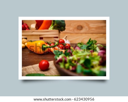 Sweet pepper, broccoli and cherry tomato. Mix salad leaves. Natural raw vegetables. Organic bio food on rustic wooden table. Photo frame design with shadow.
