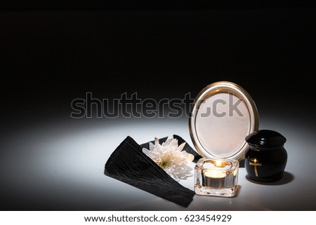 black urn with black tape,white chrysanthemum, candle,for sympathy card on background