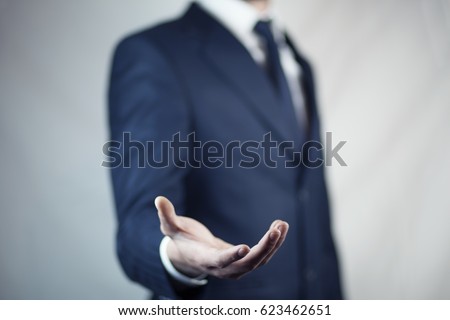 male is standing and shows outstretched hand with open palm Royalty-Free Stock Photo #623462651