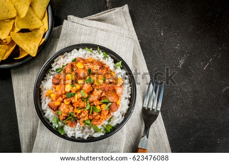 Traditional Mexican Chilean food, chili con carne, served in a portioned bowl with rice. On black concrete table, top view copy space Royalty-Free Stock Photo #623476088