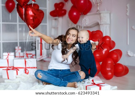 Young beautiful mother with baby playing, holiday balloons
