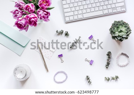 Flowers on trendy desk in office white background top view
