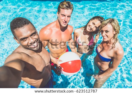 Multi-racial group of friends  having fun in a swimming pool