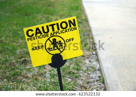 caution warning sign with text pesticide used