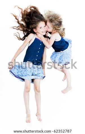 two caucasian little girls kissing affection isolated studio on white background