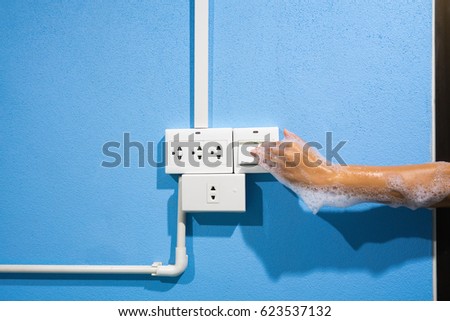 The concept of Do not turn the power off while wet hands may cause electric shock and death. Male wet hands dirty bubbles to Press the power switch lights.