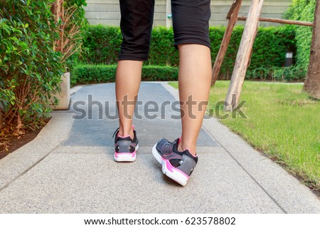 Sporty woman ankle sprain while jogging or running at park Royalty-Free Stock Photo #623578802