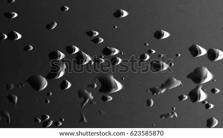 drops of water on a dark car .