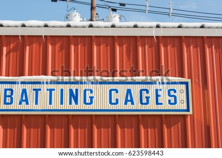 Local community batting cages at a baseball field following a spring snow storm Royalty-Free Stock Photo #623598443