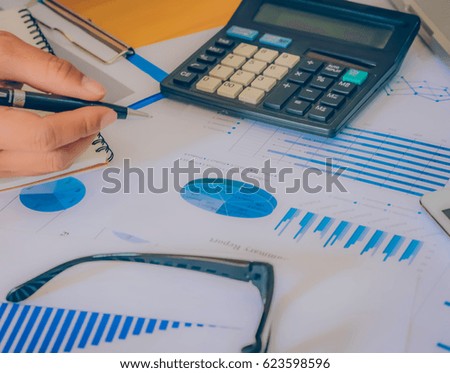 Hands of Businessman working on Laptop Computer with Data Charts
