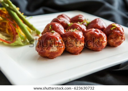 A ground meat rolled into a small size ball along with other ingredients cooked by steaming, frying, baking, with different kind of sauce