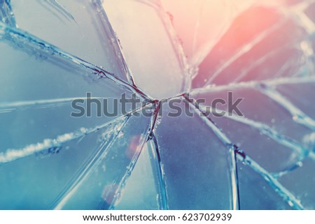Broken glass with cracks in the sunlight, background, texture