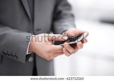 Close up of a man using mobile smart phone in office
