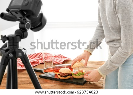 Young woman preparing for shooting food indoors