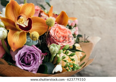 Colorful  bouquet of different fresh flowers. Bunch of orchids, roses, freesia and eucalyptus leaves. Rustic flower background. Close up