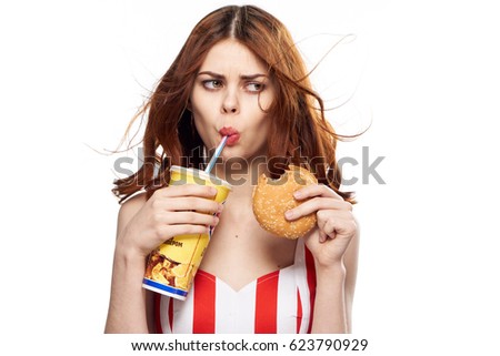      Portrait of a woman on a white background with a hamburger and soda