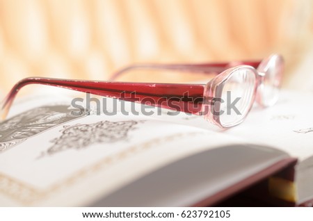 Lying open book and glasses.