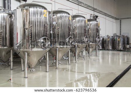 Brewery. Modern beer plant with brewering kettles, tubes and tanks made of stainless steel Royalty-Free Stock Photo #623796536