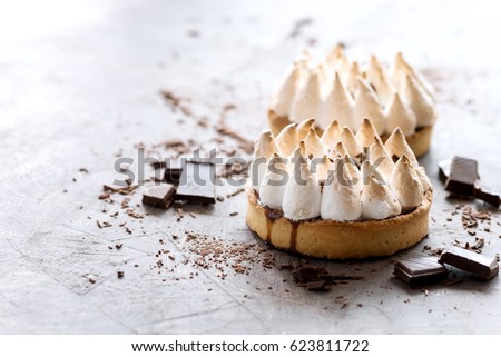 Three tarts on background Two tartlets with meringue One tartles with caramel cream and nuts Chocolate Horizontal photo Copy space 