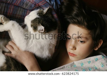 teenager boy in bed with cat cuddle close up photo