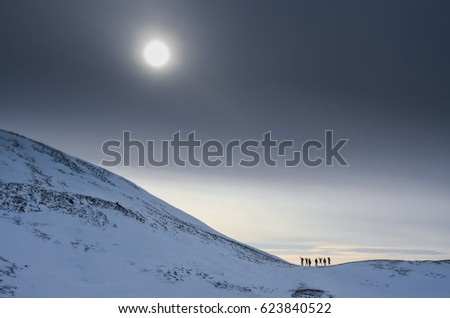 Group of tourist standing together under dark sky in winter Iceland