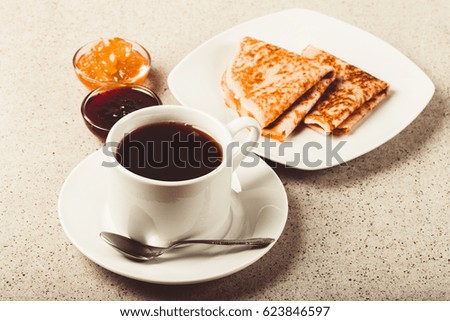 Cup of tea with jam, sour cream and russian pancakes - blini. Toned.