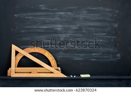Chalk rubbed out on blackboard and vintage wooden geometric measures
