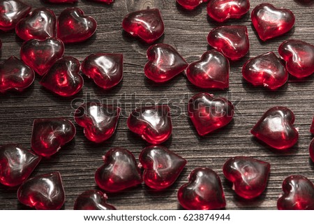 Red decorative hearts on a brown wooden background