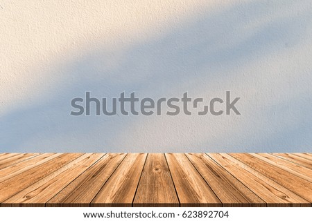 Wooden board empty table in front of blurred background. Perspective warm light and shadow bokeh on white wall can be used for display or montage your products