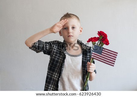 Proud  boy celebrating Memorial day with flowers and American flag