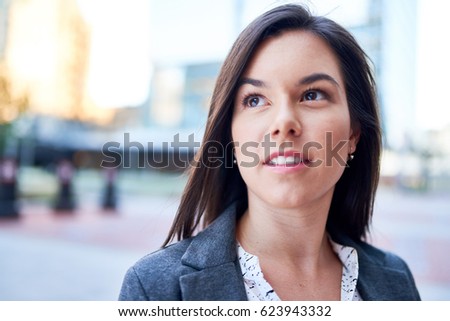 Millenial businesswoman smiling confidently with cityscape background