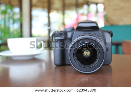 Digital camera of photographer on wooden table in coffee shop