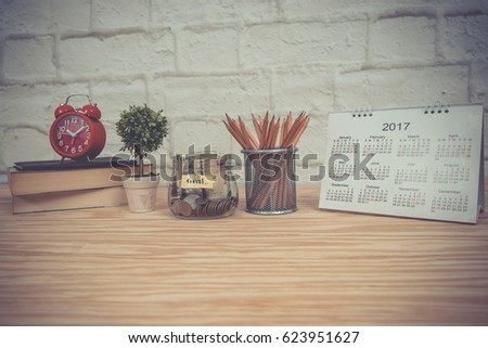 Office desk table with office equipment, calendar, books, ancient clock, pencils, money box and flowerpot. office accessories. vintage style.