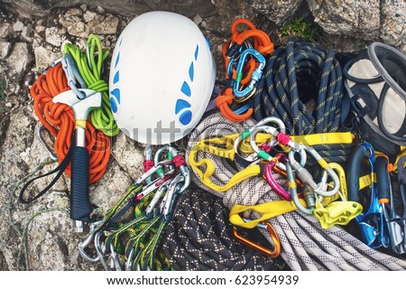 Used climbing equipment - carabiner without scratches, climbing hammer, white helmet and grey,red,green and black rope Royalty-Free Stock Photo #623954939