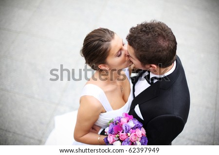 Beautiful picture of a nice young married couple kissing on a street
