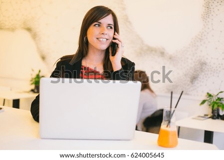Young woman siting at cafe working on laptop