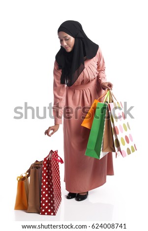 Happy pretty Asian woman carrying shopping bag on white background