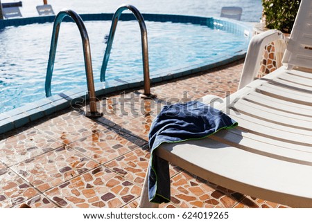 Pool and chaise-longue by sea