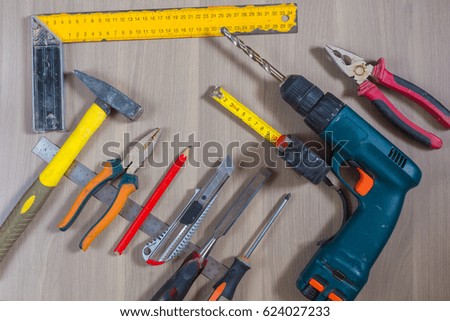 Different tools on a wooden background. Hammer, drill, pliers. Screwdriver, ruler, cutting pliers Royalty-Free Stock Photo #624027233