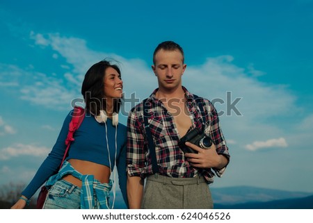 Positive man and woman tourists taking camera in hands and photographing in city. Romantic moment of stylish family. wanderlust and travel concept with space for text. Love concept. Fashion.