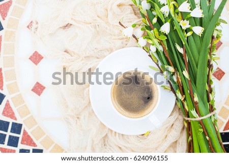Bouquet White spring bellflowers and coffee cup on table in garden. Spring morning with coffee.