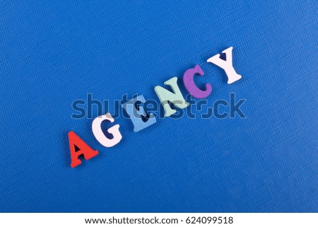 AGENCY word on blue background composed from colorful abc alphabet block wooden letters, copy space for ad text. Learning english concept