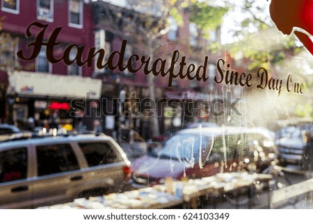 "Handcrafted since day one" sign on a storefront window.